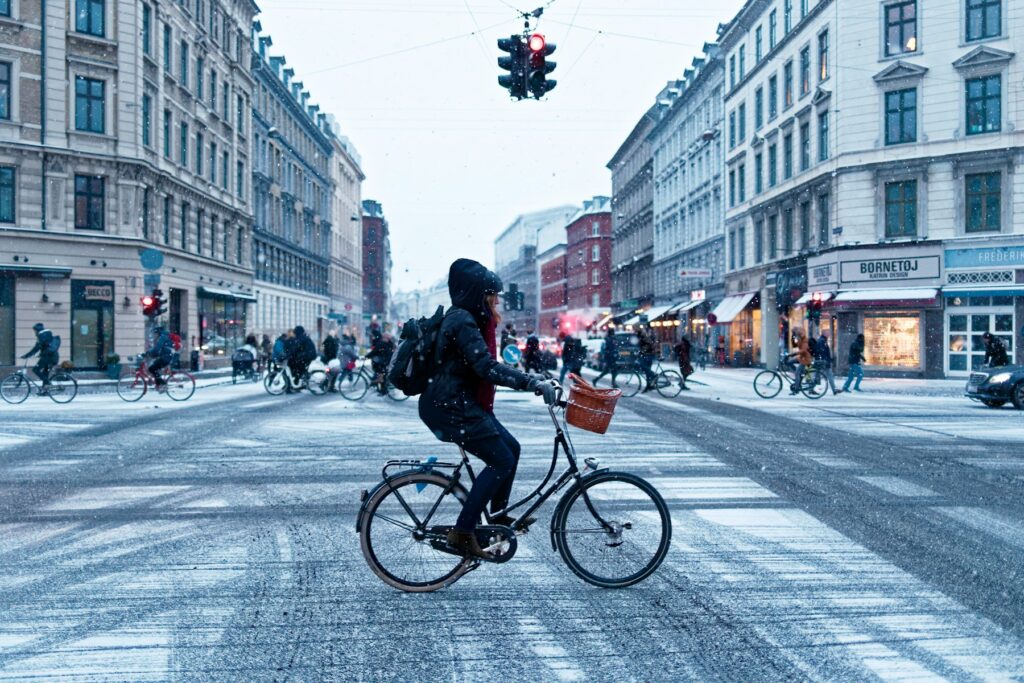 Radfahrer zwischen modernen Gebäuden in der dänischen Hauptstadt, Kopenhagen günstig mit dem Fahrrad erkunden
